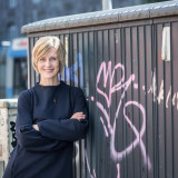 Stefanie Schardien vor einem Bauwagen mit Graffiti