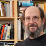 Hans Christian Kley vor Bücherregal